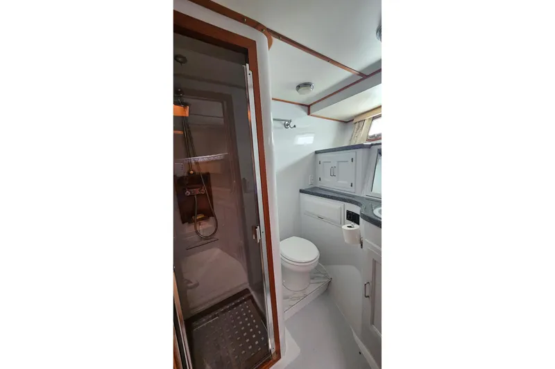 Slide: The Image of Interior of 1987 DeFever 53 POC yacht bedroom with wooden shelves and cozy bedding. - 49