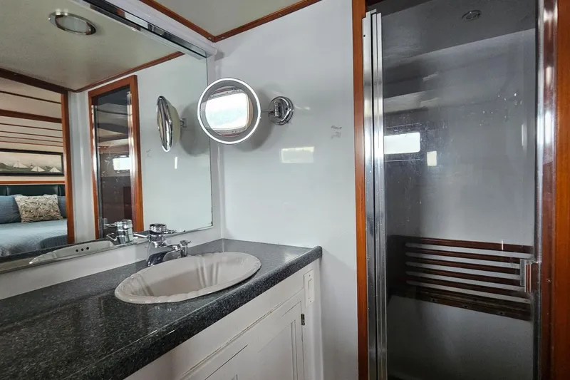 Slide: The Image of 1987 DeFever 53 POC yacht interior with wood cabinetry, TV, and cozy bedroom. - 53