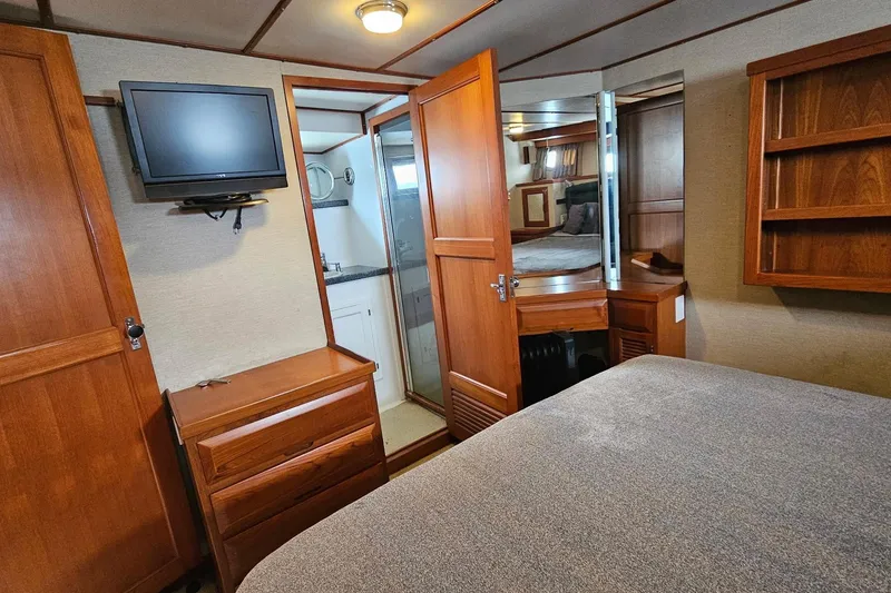 Slide: The Image of Cozy bedroom on 1987 DeFever 53 POC yacht with wooden interior and blue bedding. - 56