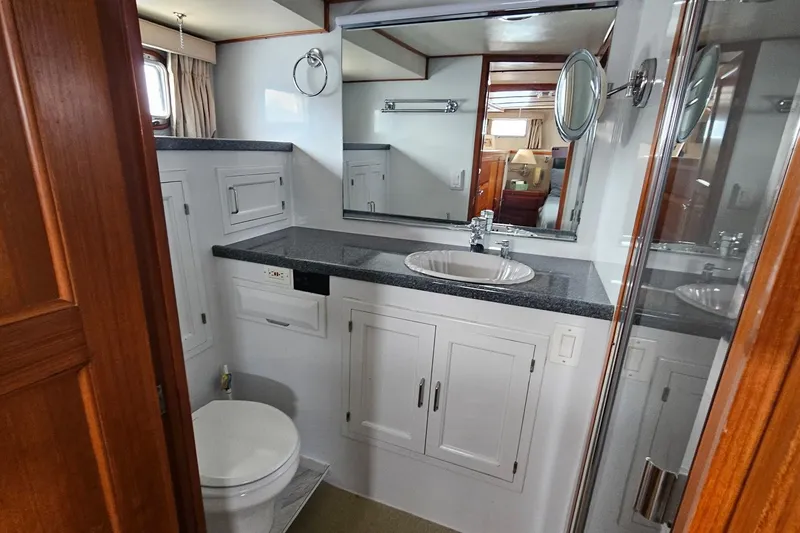 Slide: The Image of Luxurious 1987 DeFever 53 POC yacht bedroom with wood cabinets and blue bedding. - 67