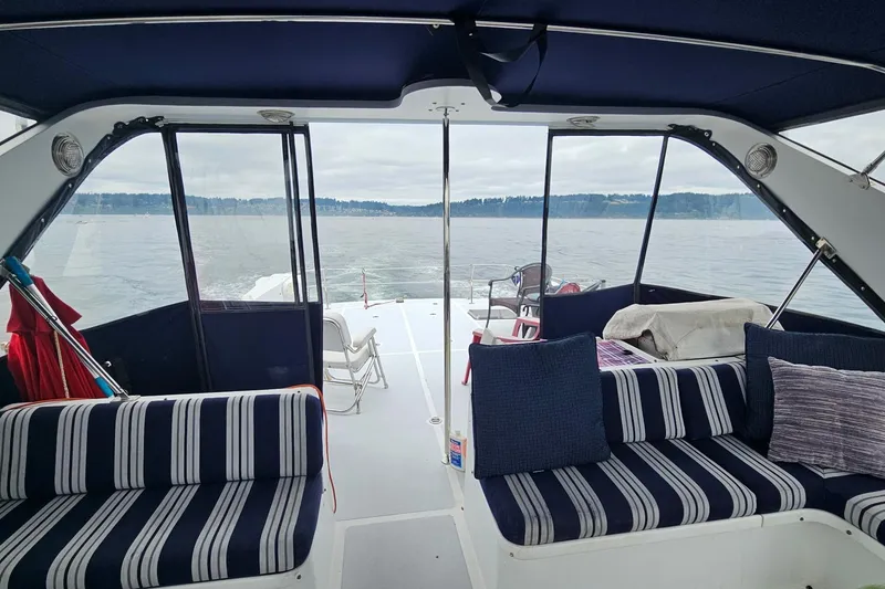 Slide: The Image of 1987 DeFever 53 POC yacht interior with striped seating and scenic ocean view. - 9