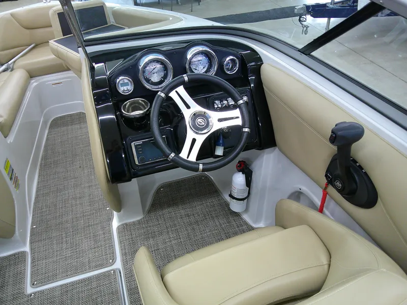 Slide: The Image of 2018 Crownline 205 SS boat interior with steering wheel and beige seating. - 11