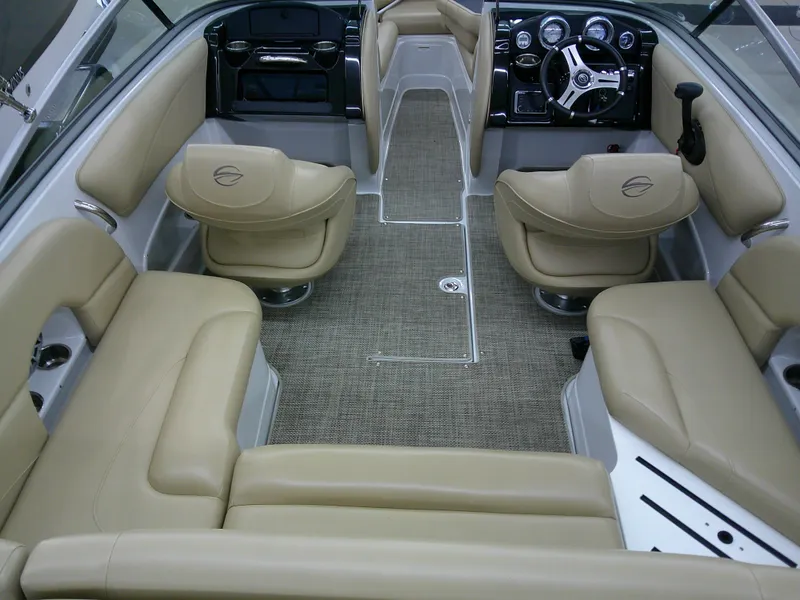 Slide: The Image of 2018 Crownline 205 SS boat interior with beige seating and modern dashboard. - 2