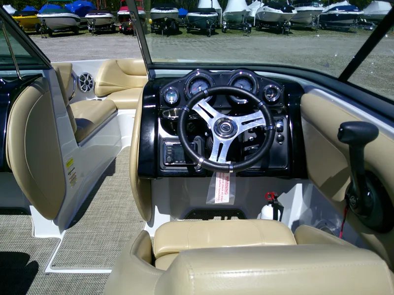 Slide: The Image of 2018 Crownline 205 SS boat interior with beige seating and modern dashboard controls. - 9