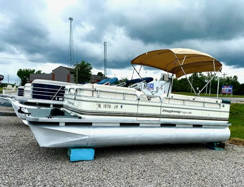 Slide: The Image of 2001 Playbuoy PB Calypso SE pontoon boat with canopy on gravel lot. - 1