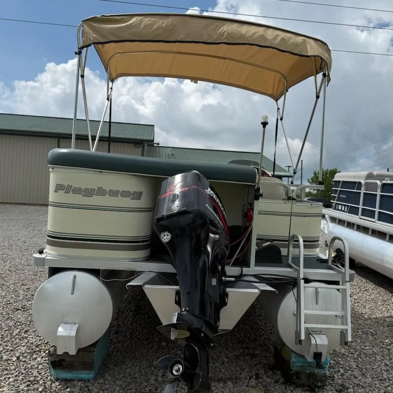 Slide: The Image of Playbuoy PB Calypso SE 2023 pontoon boat with canopy and outboard motor, parked on gravel. - 5