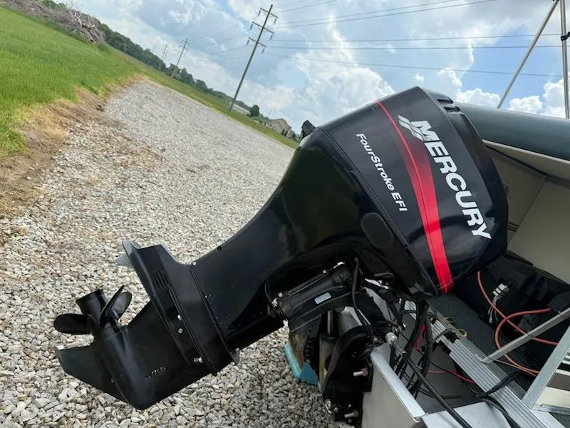 Slide: The Image of Mercury FourStroke EFI outboard motor on Playbuoy PB Calypso SE 2023, 2001 model, on gravel path. - 7