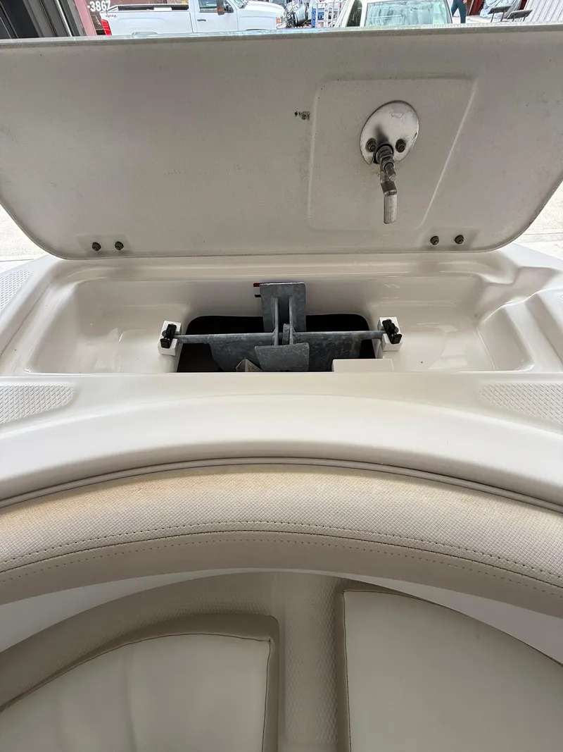 Slide: The Image of 2015 Robalo R222 Center Console storage compartment with open lid and latch mechanism. - 10
