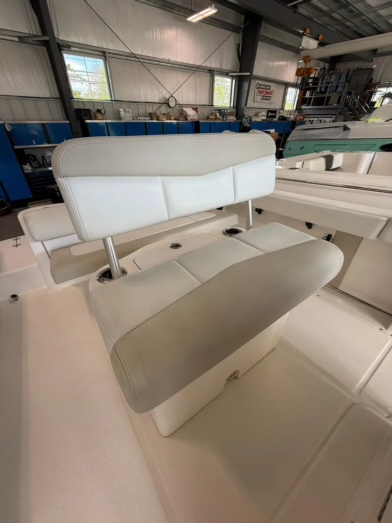 Slide: The Image of 2015 Robalo R222 Center Console boat interior with cushioned seating in a showroom. - 5