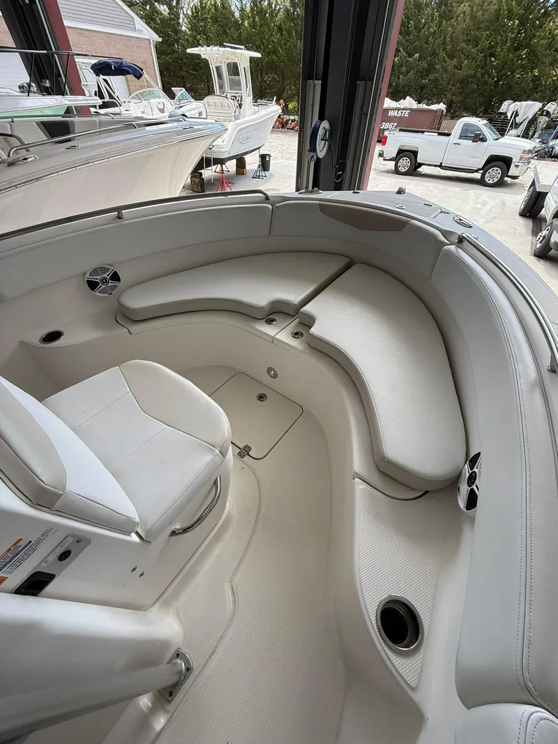 Slide: The Image of 2015 Robalo R222 Center Console boat interior with white seating and storage compartments. - 7