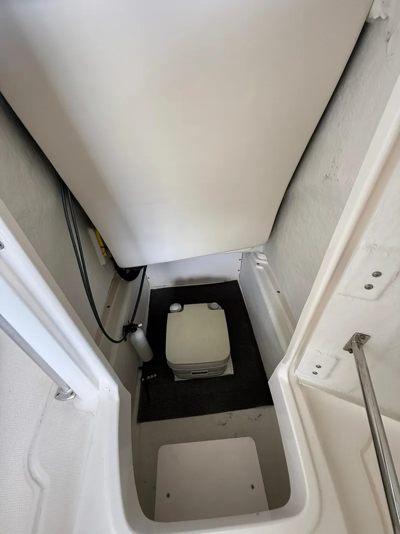 Slide: The Image of 2015 Robalo R222 Center Console boat interior with compact toilet. - 8