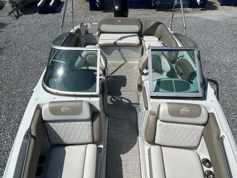 Slide: The Image of 2021 Crownline Eclipse E215 XS boat interior with beige seating and open windshield. - 10