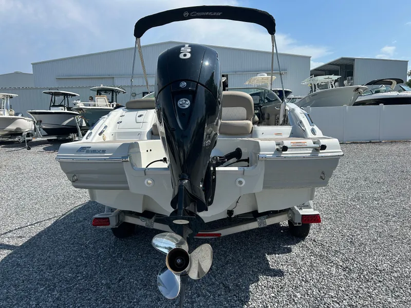 Slide: The Image of 2021 Crownline Eclipse E215 XS boat with outboard motor, parked on gravel. - 4