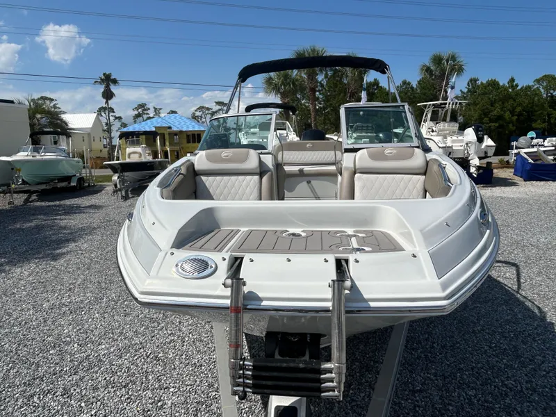 Slide: The Image of 2021 Crownline Eclipse E215 XS boat on display in a marina setting. - 7