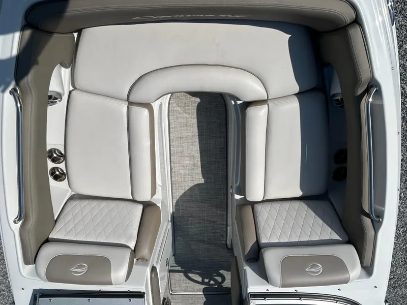 Slide: The Image of 2021 Crownline Eclipse E215 XS boat interior with cushioned seating and carpeted flooring. - 9