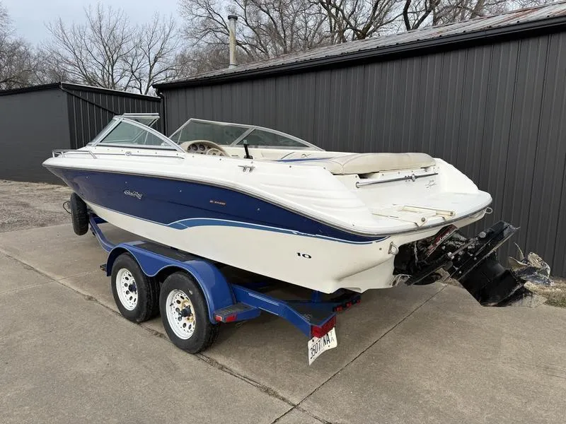 Slide: The Image of 1996 Sea Ray 210 Signature boat on trailer, parked outdoors near a building. - 4