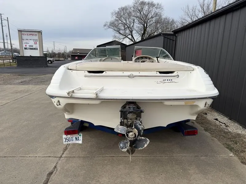 Slide: The Image of 1996 Sea Ray 210 Signature boat, rear view, parked on concrete near a building. - 6