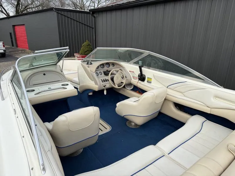 Slide: The Image of Interior of a 1996 Sea Ray 210 Signature boat with white seating and blue carpet. - 7