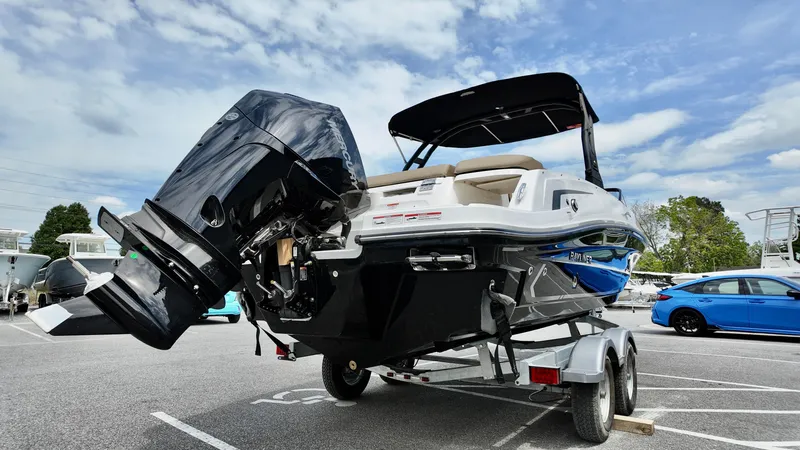 Slide: The Image of 2025 Bayliner VR6 boat on trailer, parked outdoors under a partly cloudy sky. - 16