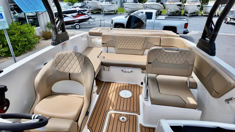 Slide: The Image of 2025 Bayliner VR6 boat interior with beige seating and wood-style flooring. - 7