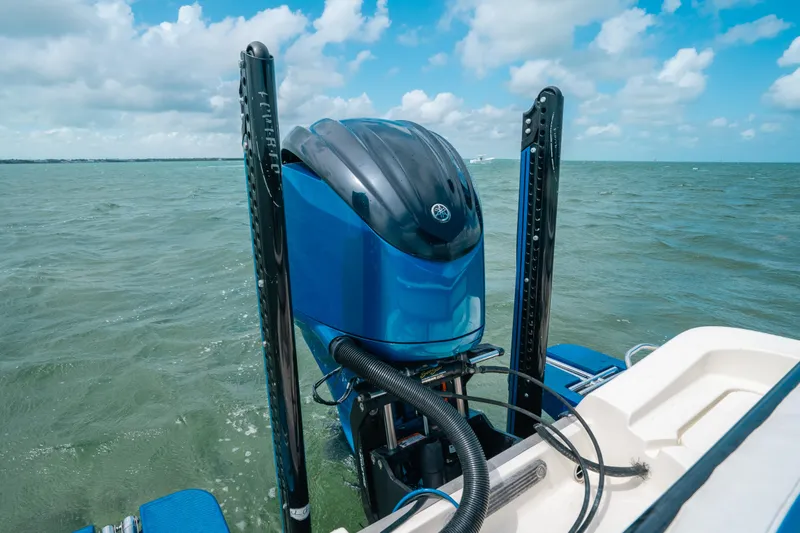 Slide: The Image of 2015 Hydra-Sports 23 Bay boat engine on water, under a partly cloudy sky. - 22