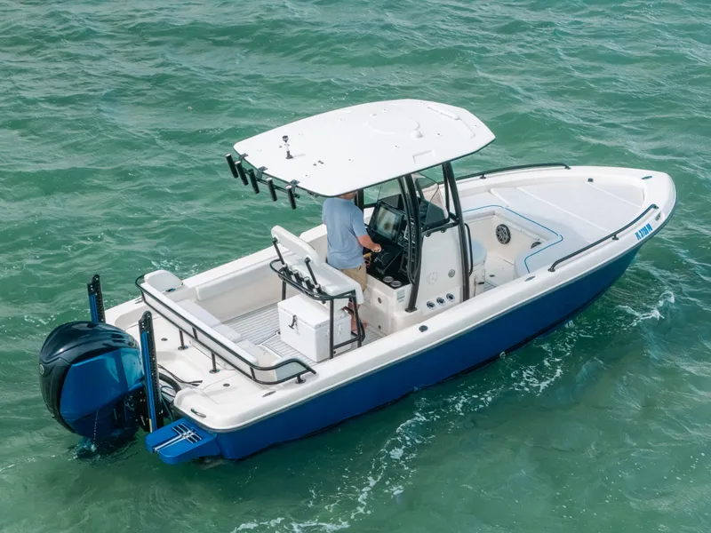 Slide: The Image of 2015 Hydra-Sports 23 Bay boat cruising on water, featuring a blue hull and white deck. - 24