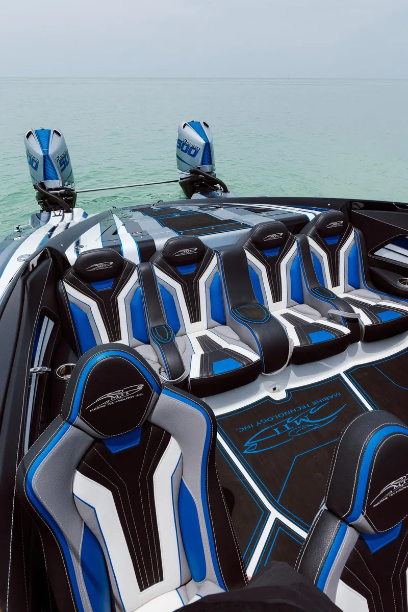 Slide: The Image of Luxury MTI 440X 2024 speedboat with sleek blue and black seating on calm water. - 29