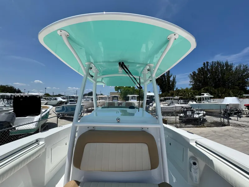 Slide: The Image of 2015 Southport 29 FE boat with teal canopy, docked under clear blue sky. - 16