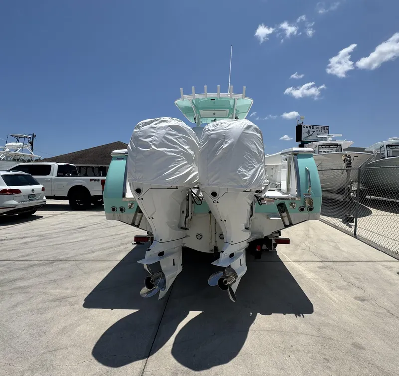 Slide: The Image of 2015 Southport 29 FE boat with twin outboard motors in a sunny marina. - 2