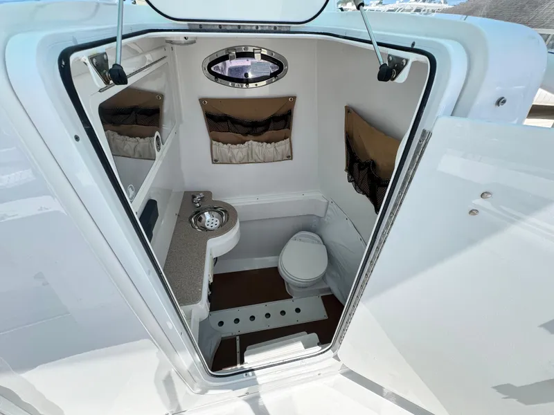 Slide: The Image of 2015 Southport 29 FE boat interior with compact bathroom and modern amenities. - 20