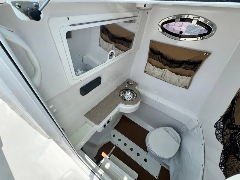Slide: The Image of Interior of 2015 Southport 29 FE boat featuring compact bathroom amenities. - 21