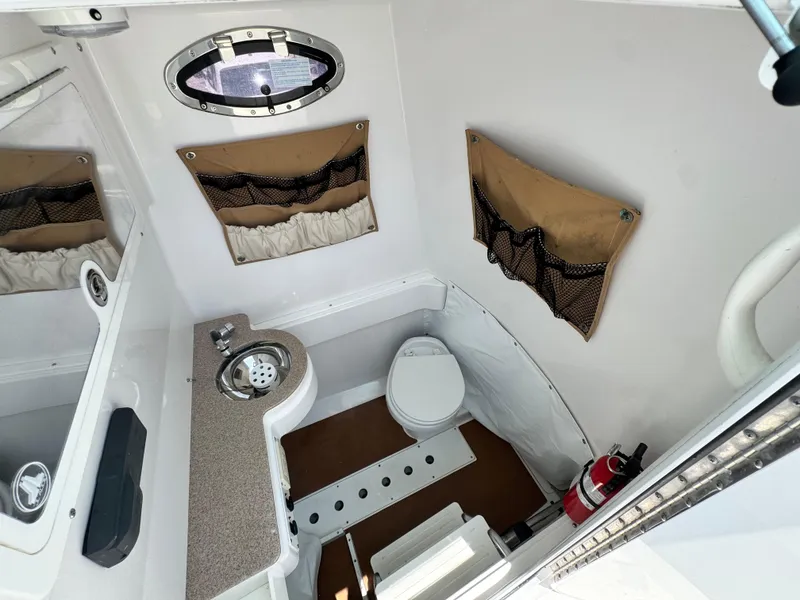 Slide: The Image of Interior of 2015 Southport 29 FE boat bathroom with sink, toilet, and fire extinguisher. - 22
