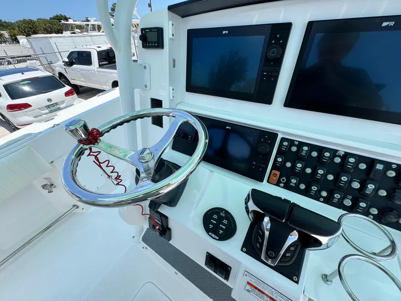 Slide: The Image of Control panel of a 2015 Southport 29 FE boat with steering wheel and navigation screens. - 25