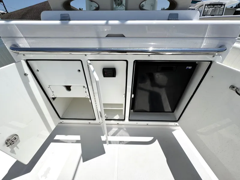 Slide: The Image of 2015 Southport 29 FE boat storage compartments with open doors, showcasing interior space. - 32