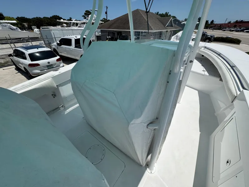 Slide: The Image of 2015 Southport 29 FE boat deck with covered console, parked near vehicles. - 7