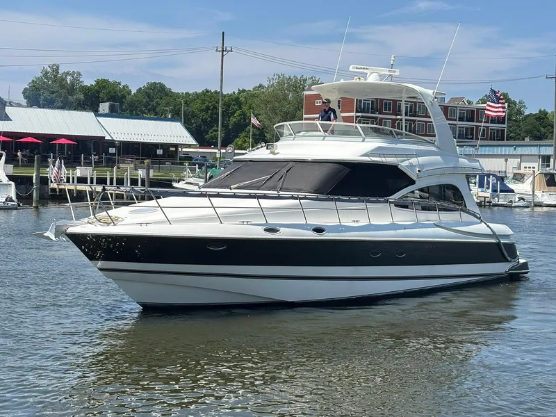 Slide: The Image of 2003 Cruisers Yachts 5000 Sport Sedan on water near marina, sunny day. - 0