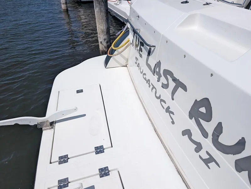 Slide: The Image of 2003 Cruisers Yachts 5000 Sport Sedan docked, showing rear deck and partial boat name. - 11