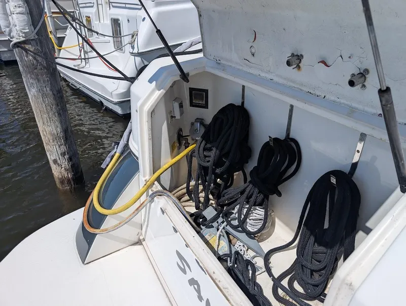 Slide: The Image of 2003 Cruisers Yachts 5000 Sport Sedan with coiled ropes and dock connections. - 12
