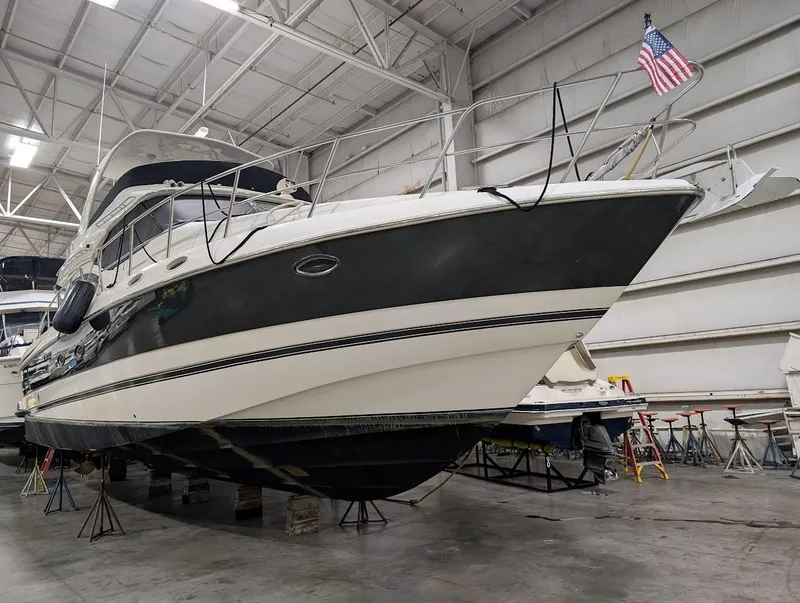 Slide: The Image of 2003 Cruisers Yachts 5000 Sport Sedan in indoor storage, American flag displayed. - 27