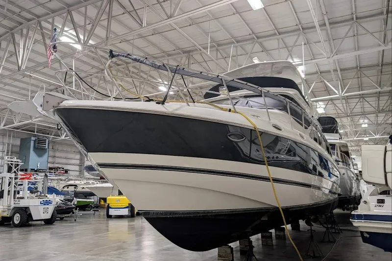 Slide: The Image of 2003 Cruisers Yachts 5000 Sport Sedan in a spacious indoor marina. - 28