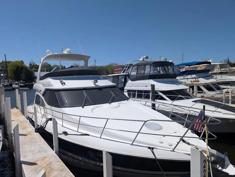 Slide: The Image of 2003 Cruisers Yachts 5000 Sport Sedan docked at marina under clear blue sky. - 3
