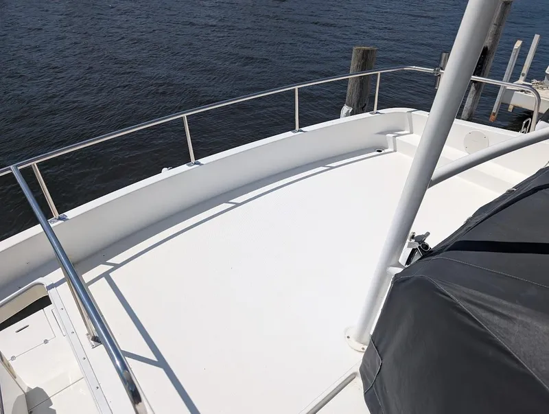 Slide: The Image of 2003 Cruisers Yachts 5000 Sport Sedan deck with railing, docked by calm water. - 35