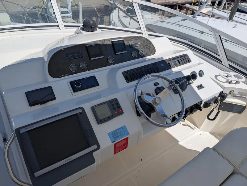 Slide: The Image of 2003 Cruisers Yachts 5000 Sport Sedan helm with modern navigation equipment and steering wheel. - 37