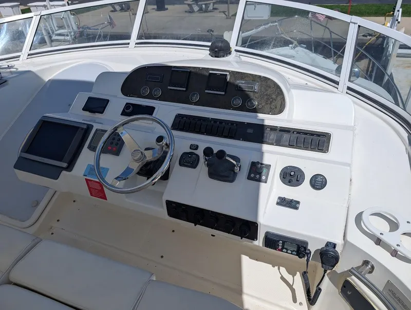 Slide: The Image of 2003 Cruisers Yachts 5000 Sport Sedan helm with steering wheel and navigation controls. - 40