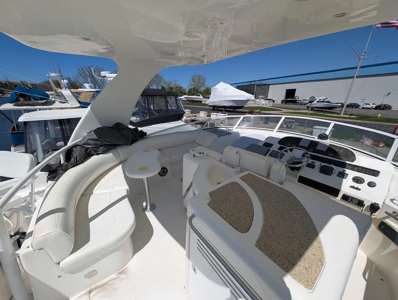 Slide: The Image of 2003 Cruisers Yachts 5000 Sport Sedan interior with seating and control panel, docked at marina. - 45