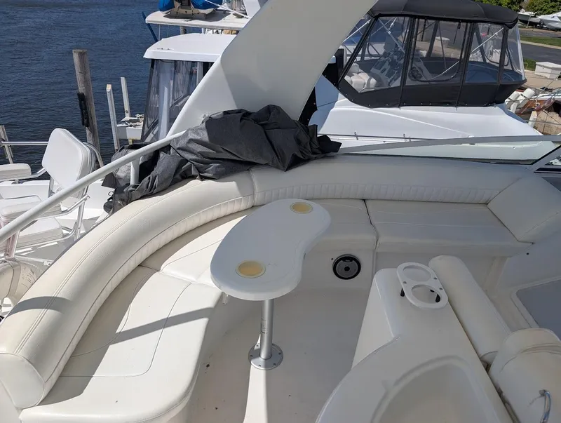 Slide: The Image of 2003 Cruisers Yachts 5000 Sport Sedan with white seating and table on deck. - 46