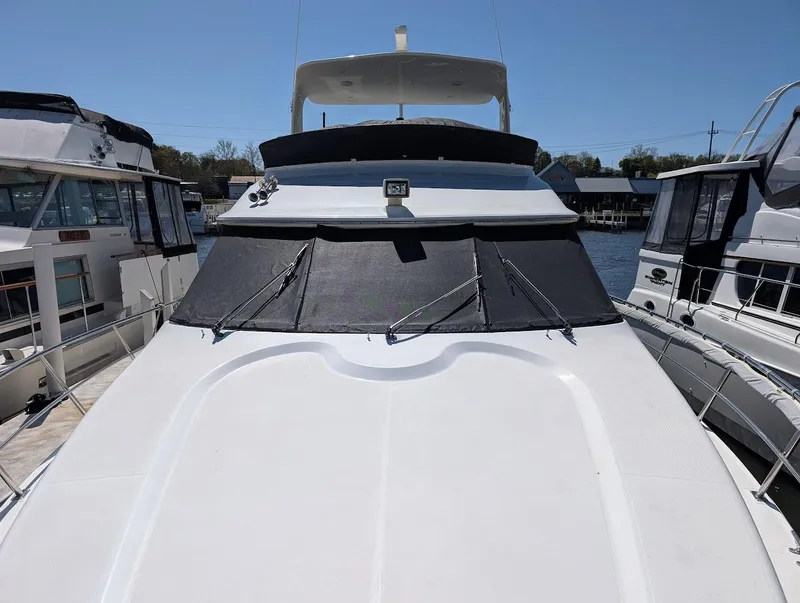 Slide: The Image of 2003 Cruisers Yachts 5000 Sport Sedan docked, featuring sleek design and spacious deck. - 6