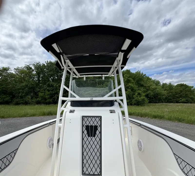 Slide: The Image of 2018 Wellcraft 182 Fisherman boat with T-top, parked outdoors under cloudy sky. - 10
