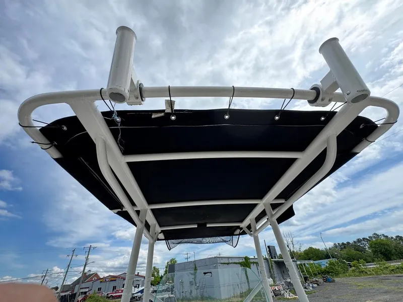 Slide: The Image of 2018 Wellcraft 182 Fisherman T-top with rod holders against a cloudy sky. - 16