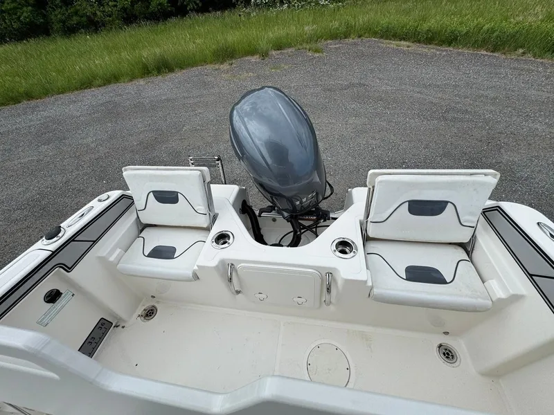 Slide: The Image of 2018 Wellcraft 182 Fisherman boat with dual seats and outboard motor, parked on gravel. - 17